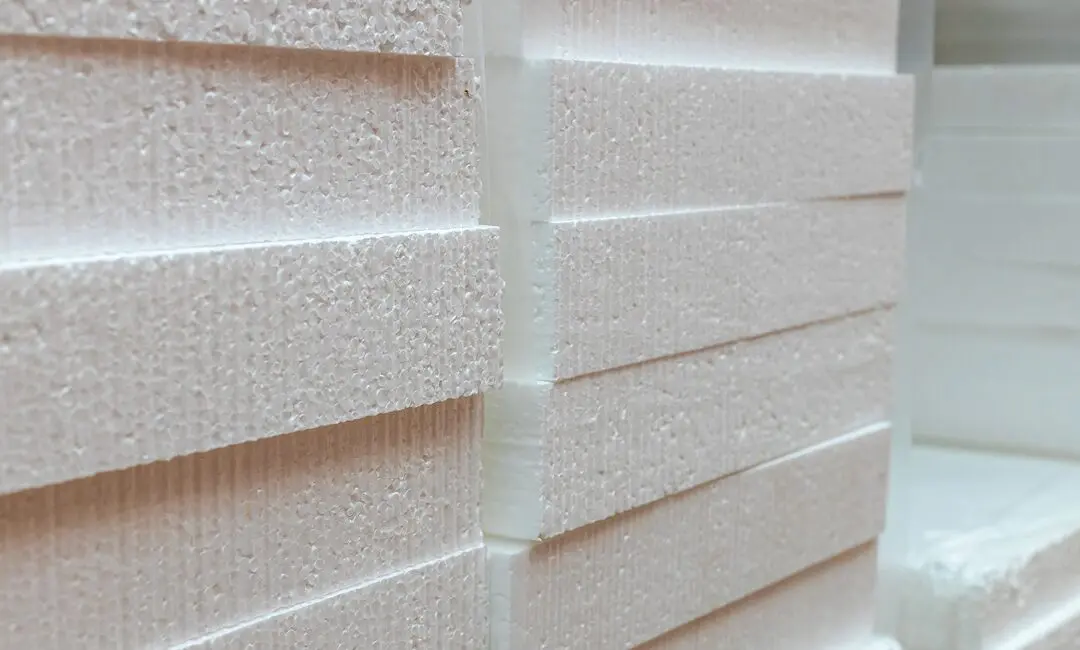 Stacked white expanded polystyrene (EPS) foam sheets showing the fused bead cell structure